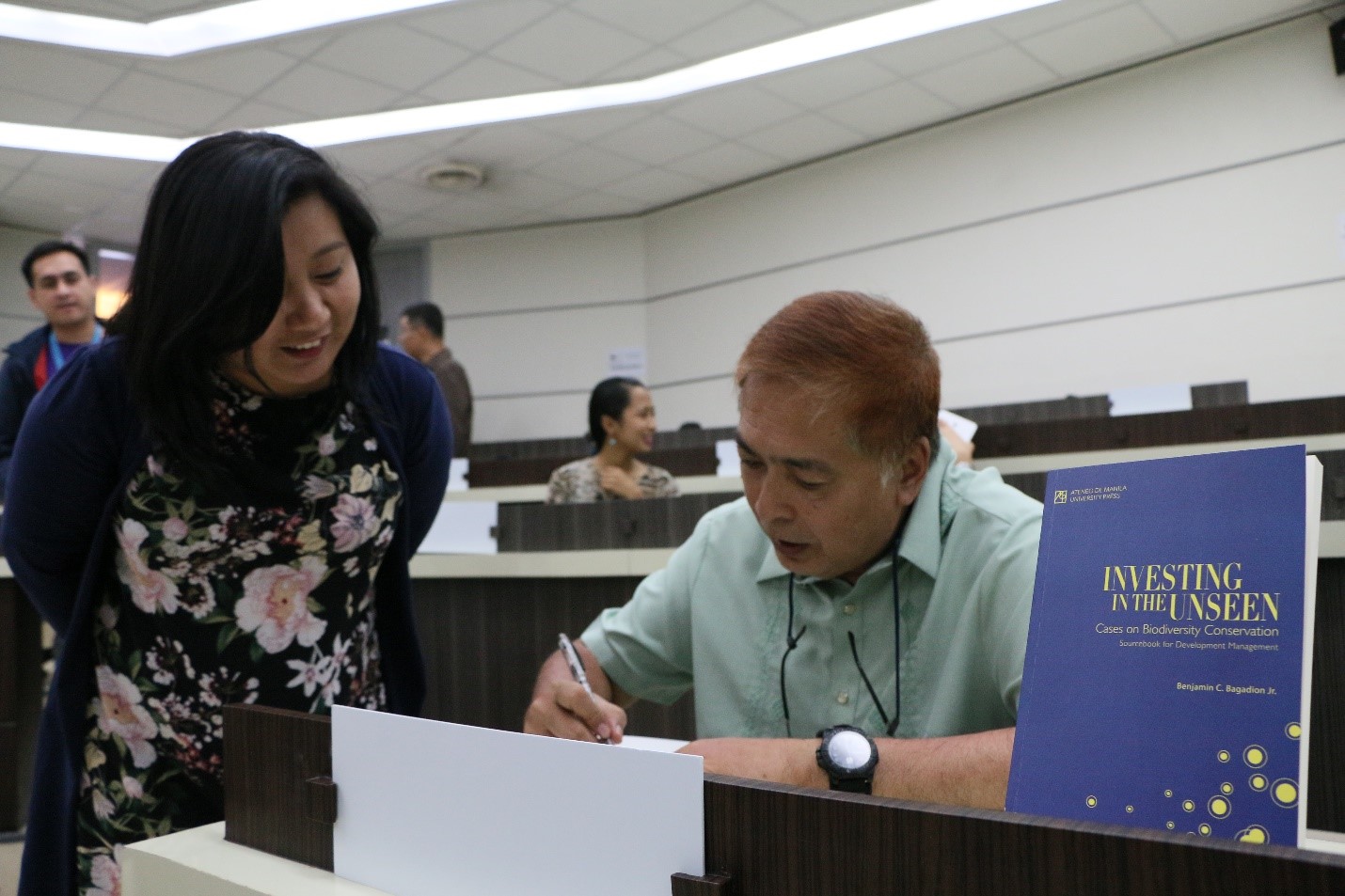 Bagadion signing a copy of the book during the launch