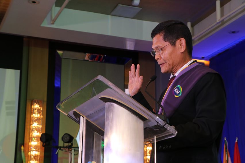 Mr. Diosdado Domingo, MBM 1988, leading the oath taking during the induction of graduates to the AIM Alumni Association