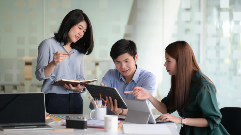 A team of professional designers with laptop and devices are bra
