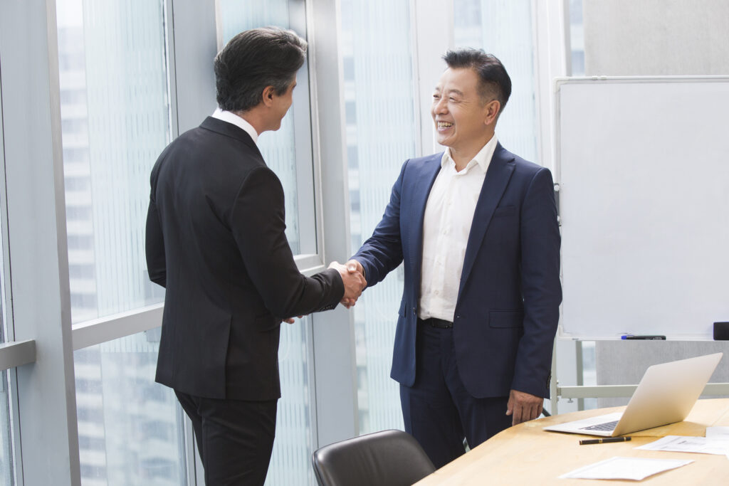 Businessmen shaking hands in meeting room