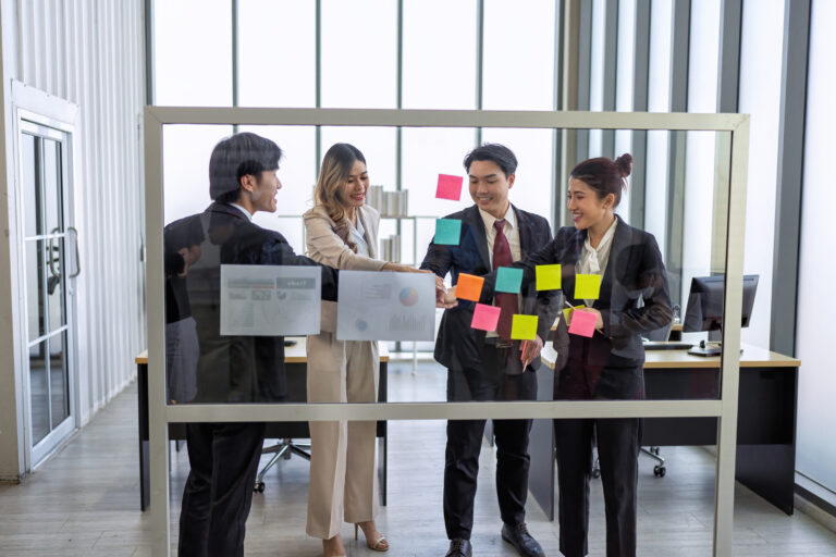 Employee meeting at office and use post it notes to share idea brainstorming stick on glass wall