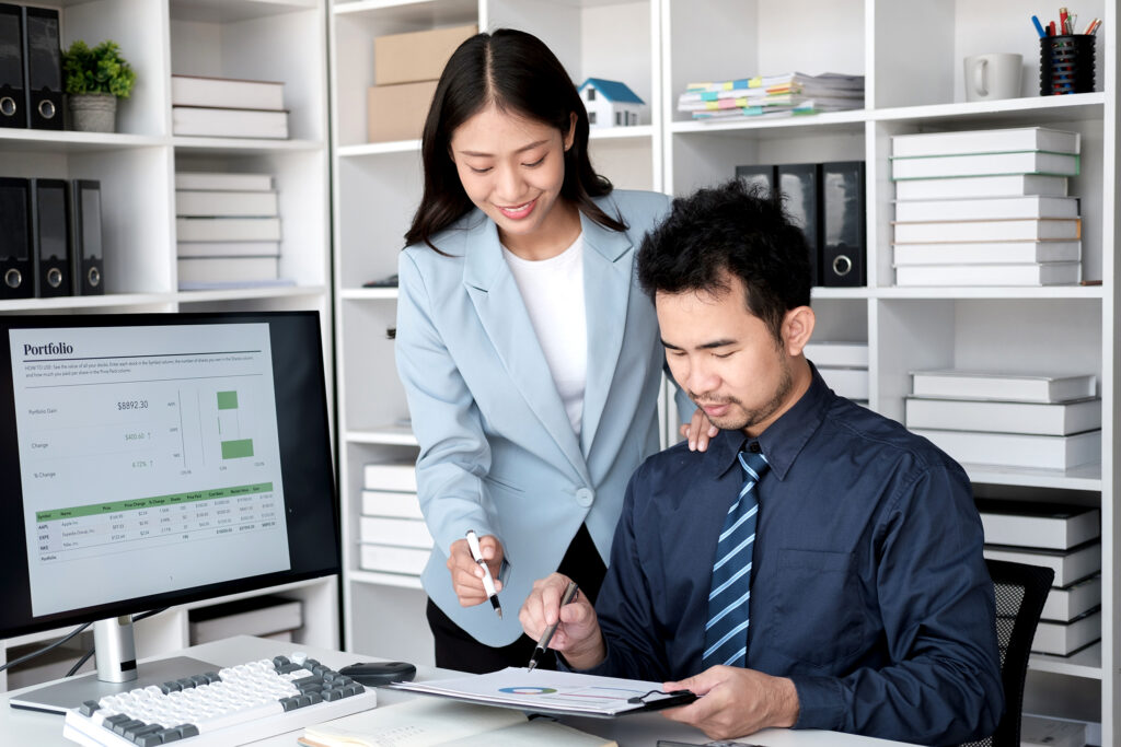 Young professional business team working and analyzing the project together, using desktop monitor in the office room.