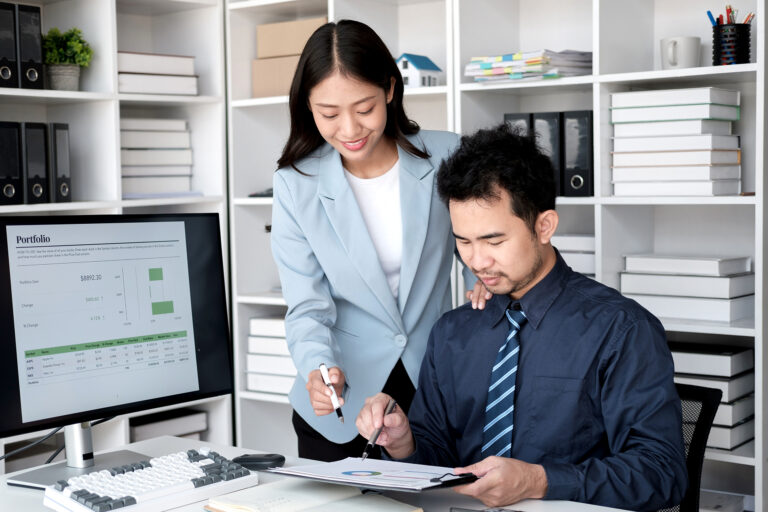 Young professional business team working and analyzing the project together, using desktop monitor in the office room.