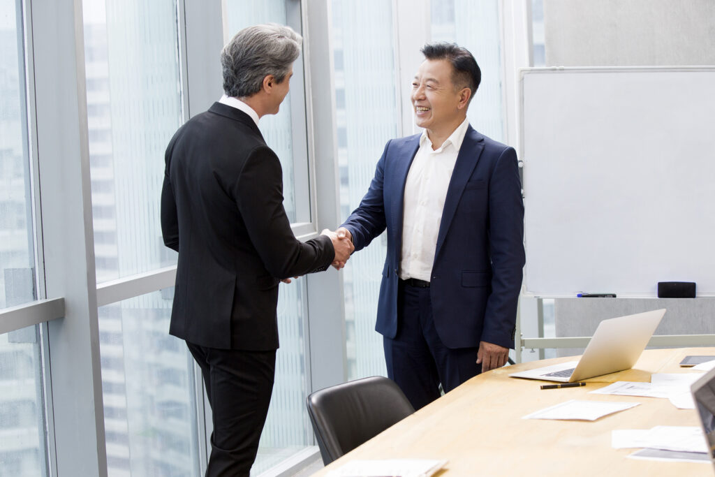 Businessmen shaking hands in meeting room