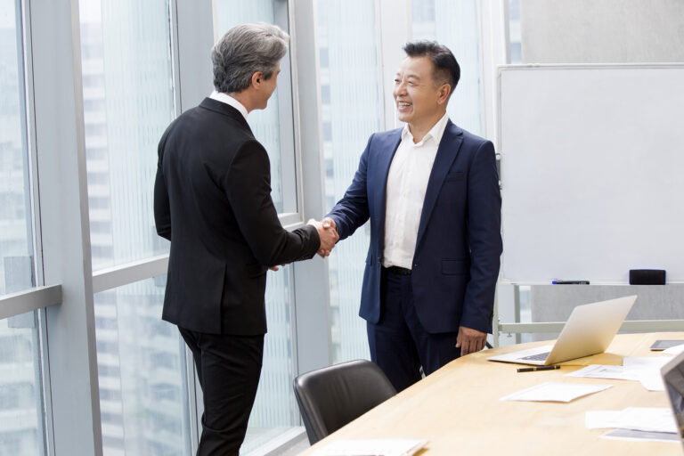 Businessmen shaking hands in meeting room