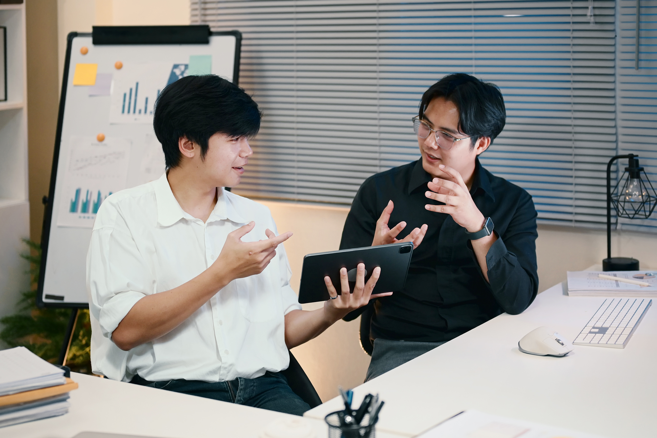 Colleagues brainstorming together at night, discussing ideas while in a modern office