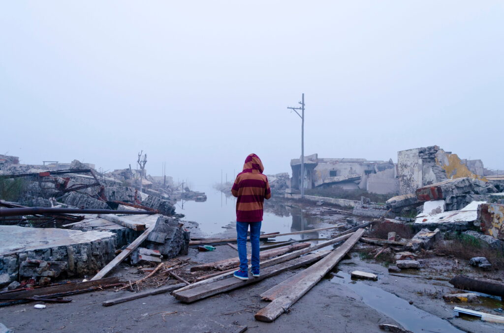 a boy watching the ruined town