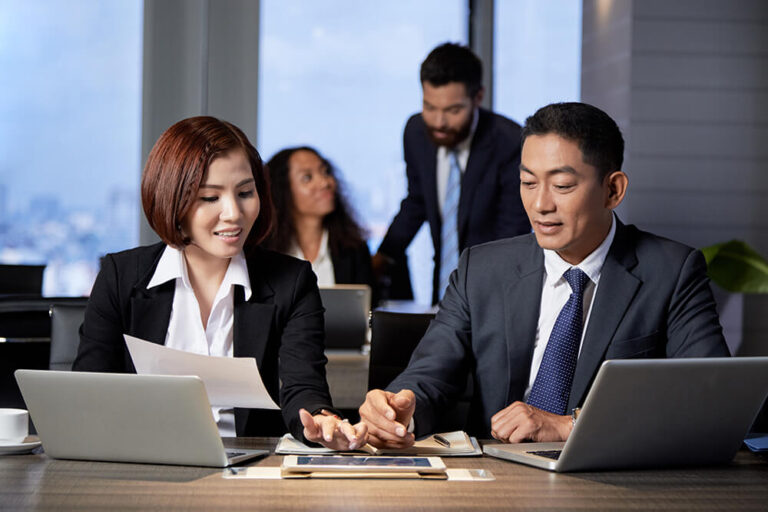 Business executives collaborating during a strategy meeting as part of an Executive MBA leadership learning experience.
