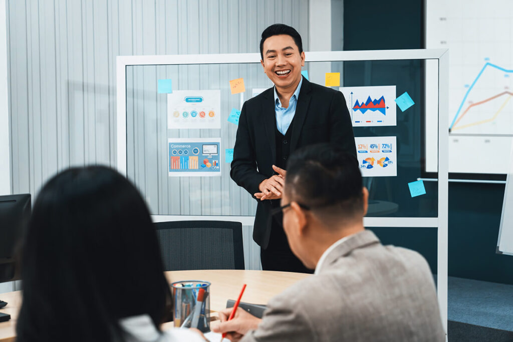 Senior executive presenting a business strategy during a leadership meeting, reflecting the strategic thinking developed through an Executive MBA.