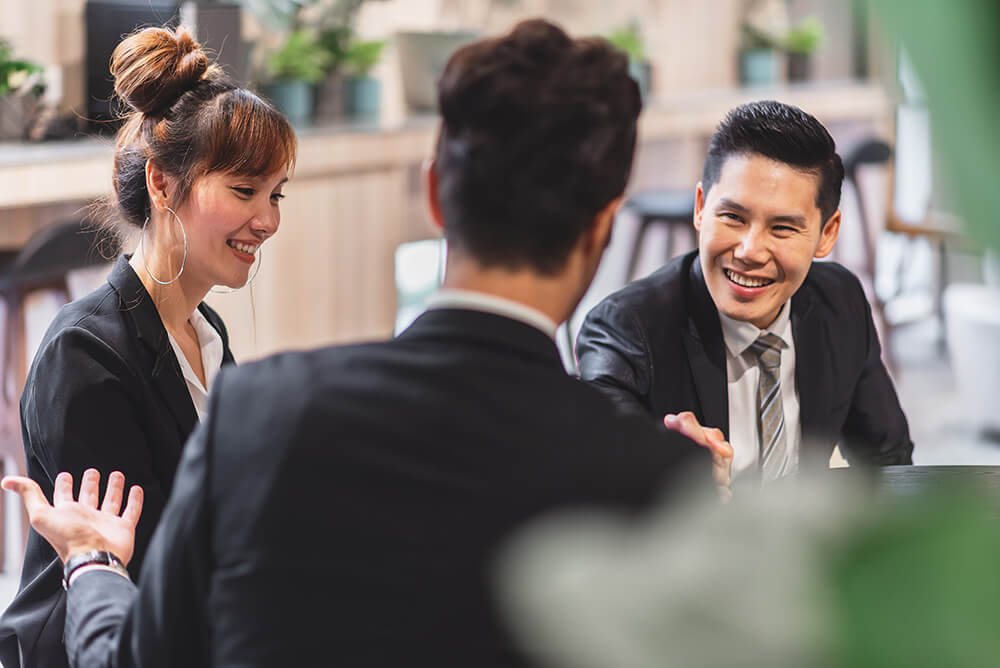 Mid-career professionals networking and exchanging ideas during an Executive MBA discussion in a collaborative learning environment.