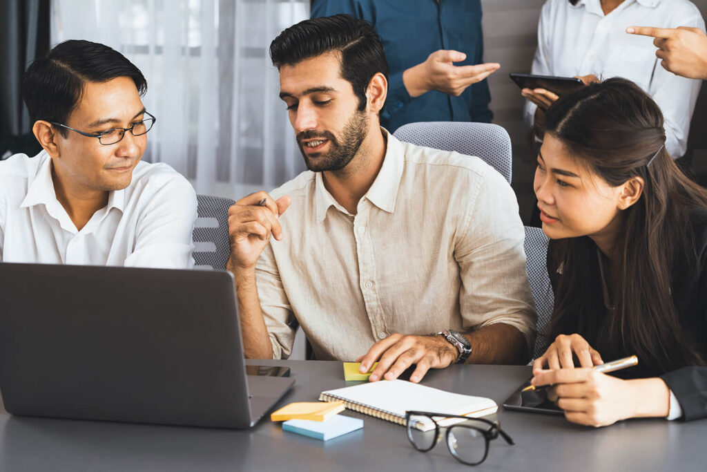 MBA classmates collaborating on a case study during a group discussion, reflecting the case-based learning approach at the core of AIM's iMBA program.