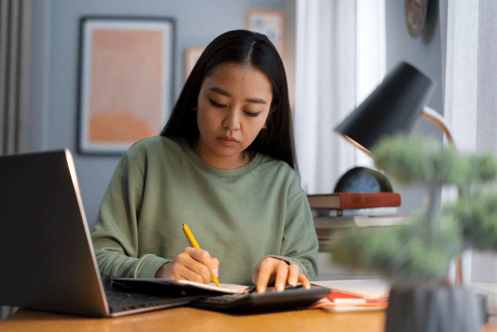 A woman computing the cost of university education across Asia.