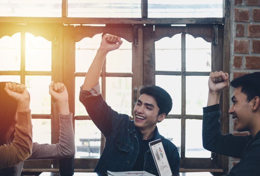 Students celebrating during a group project meeting.